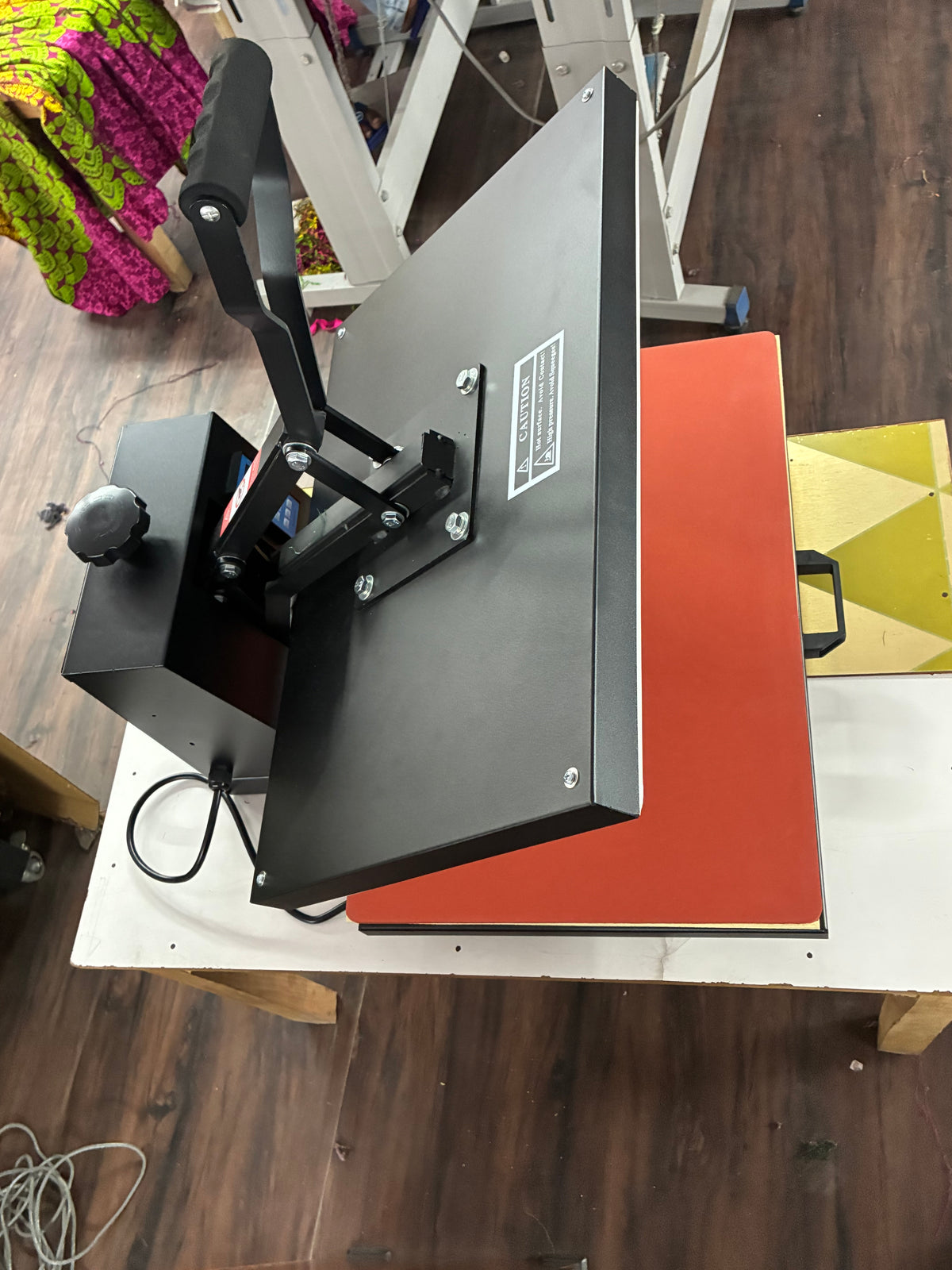 Industrial heat press machine applying custom graphics and DTF transfers on premium T-shirts and fashion apparel