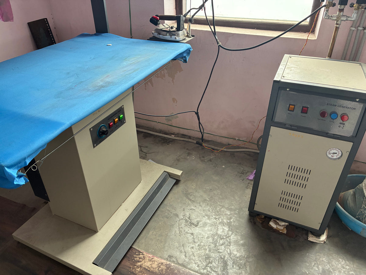 Professional steam press unit finishing garments for wrinkle-free presentation before quality inspection and export packaging